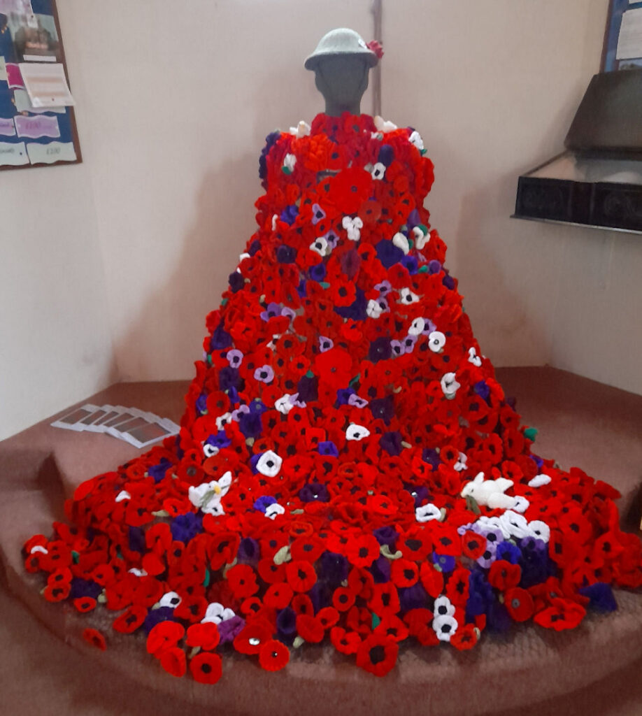 knitted poppies on a soldier manikin